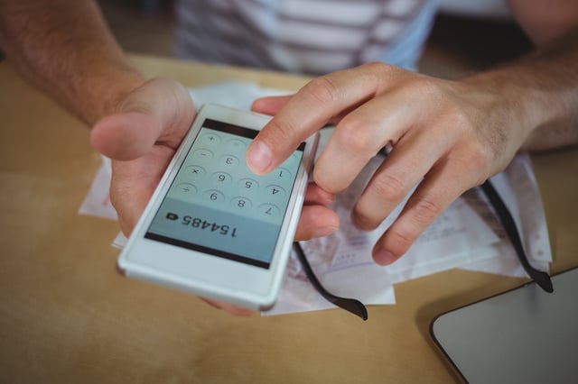 Man calculating bills on mobile phone